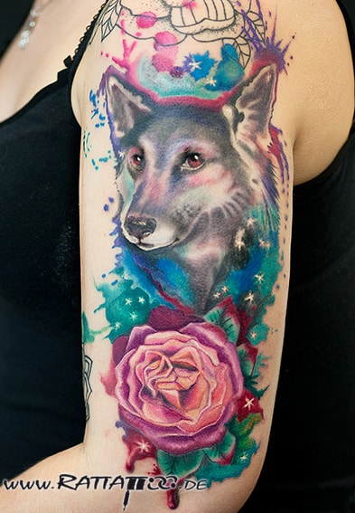 Hunde Portrait Tattoo im Aquarell Stil mit Rose in Farbe auf dem Oberarm aus dem Rattattoo Tattoostudio in Freiburg.