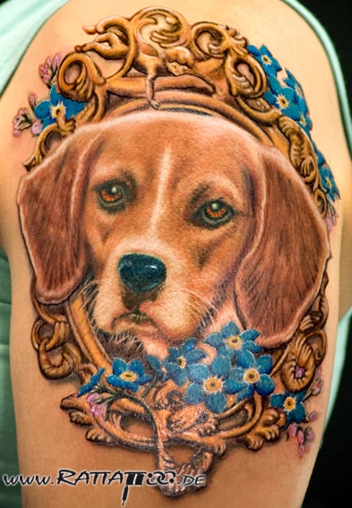 Realistisches Hunde Portrait Tatto mit Blumen und Rahmen in Farbe auf dem Oberarm aus dem Rattattoo Tattoostudio in Freiburg.