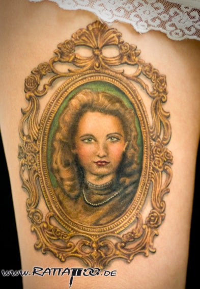 Realistisches Farbportrait von Oma mit Goldrahmen auf dem Oberschenkel aus dem Rattattoo Tattoostudio in Freiburg.